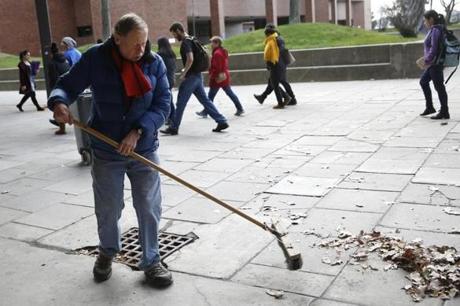 Bob Carroll, a longtime janitor at UMASS Boston, swept leaves on campus.
