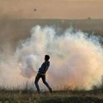 A Palestinian protester threw a tear gas canister back at Israeli forces during clashes near the Israel-Gaza border east of Gaza City on Saturday. 