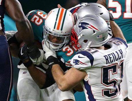 Miami Gardens, FL - 12/11/2017 - {1st quarter) New England Patriots middle linebacker Trevor Reilly (51) wraps up Miami Dolphins running back Kenyan Drake (32) during the first quarter. The New England Patriots visit the Miami Dolphins in a Monday night football game at Hard Rock Stadium, Miami Gardens, FL. - (Barry Chin/Globe Staff), Section: Sports, Reporter: James M. McBride, Topic: 12Patriots-Dolphins, LOID:8.4.335853716.
