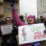Diane Tepfer held a sign with an image of Federal Communications Commission Chairman Ajit Pai as the 