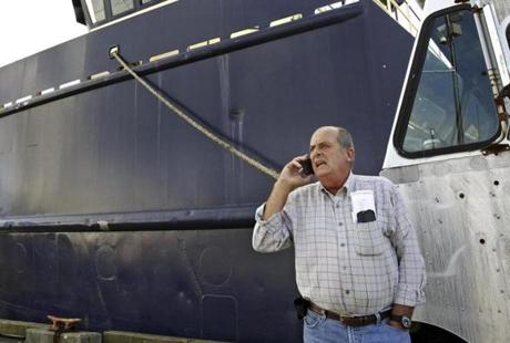 Carlos Rafael talked on the phone at Homer's Wharf in New Bedford near his herring boat F/V Voyager. 
