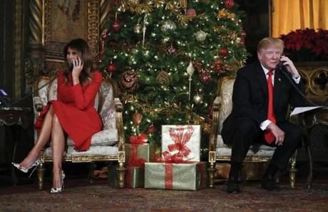 President Donald Trump and first lady Melania Trump speak on the phone with children as they track Santa Claus' movements with the North American Aerospace Defense Command (NORAD) Santa Tracker on Christmas Eve at the president's Mar-a-Lago estate in Palm Beach, Fla., Sunday, Dec. 24, 2017. (AP Photo/Carolyn Kaster)

