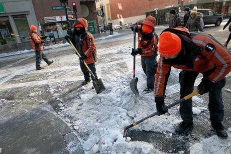 Workers for the Downtown Boston Business Improvement District cleared ice and snow from the intersection of Arch and Summer Streets.
