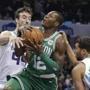 Boston Celtics' Terry Rozier (12) is fouled as he drives between Charlotte Hornets' Frank Kaminsky (44) and Michael Carter-Williams (10) during the first half of an NBA basketball game in Charlotte, N.C., Wednesday, Dec. 27, 2017. (AP Photo/Chuck Burton)