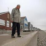 SCITUATE, MA - 12/18/2017: Humarock long time resident, Don Hourihan on his property ( red brick home ) stands on his seawall. Humarock penisula where 90 homes are perched on a narrow stretch of land where winter storms wash cobble ( stones ) from the beach every year blocking the only road in and out. The town wants a dune and raised road to protect the homes but some residents want to block the project. (David L Ryan/Globe Staff ) SECTION: METRO TOPIC 19humarock
