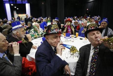 Joseph Carcerano of Brighton (center) and Dennis DeMello of Brighton (right) used noisemakers as they counted down to an early New Year at the Seaport World Trade Center on Thursday.
