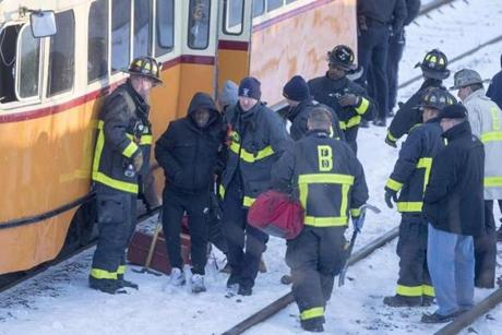 Firefighters help injured passengers off of a Mattapan high-sped line trolley after it crashed near Cedar Grove Station on Friday.

