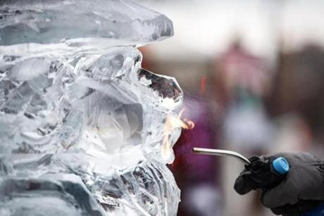 An artist shone his ice sculpture using flame in Copley Square.
