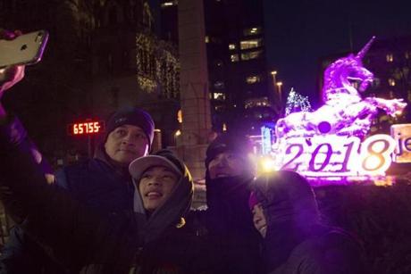 The Chan family from Framingham took a selfie in front of a unicorn carved from ice.
