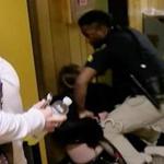 In an image from video, middle school English teacher Deyshia Hargrave is handcuffed by a city marshal after complying with a marshal's orders to leave a Vermilion Parish School Board meeting in Abbeville, La. Hargrave was removed from the school board meeting, forcibly handcuffed and jailed after questioning pay policies during a public comment period. 