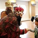 Tomas Gonzales, portraying one of the Three Kings, greeted Edrick Claudio at a Roxbury celebration Saturday. 