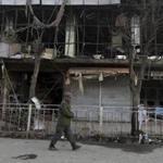 A member of the Afghan security forces walked past a building damaged in Saturday?s blast.
