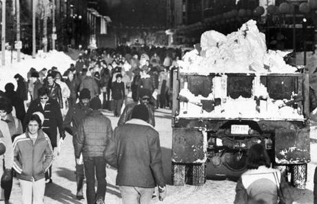 '78 BLIZZARD SLIDER Boston, MA - 2/10/1978: A truck filled with snow passes pedestrians on Boylston Street in Boston at 2 p.m. on Feb. 10, 1978, following a blizzard. The storm dropped 23.6 inches of snow on Boston over 32 hours and 40 minutes, between Feb. 5 and Feb. 7,leaving the city with 27.1 inches of snow. (Stan Grossfeld/Globe Staff) --- BGPA Reference: 141205_CB_005
