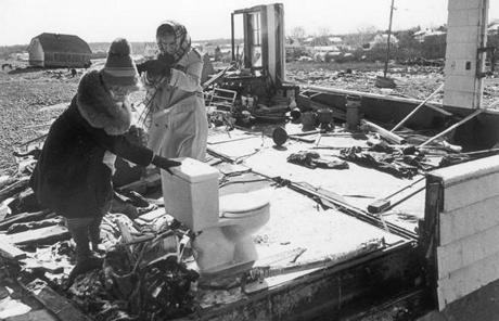 '78 BLIZZARD SLIDER OPS photo by david L. ryan Feb 10 1978 At her house in Scituate Mrs. Joseph Conley leans on her bathroom utility as she leaves her home with her is Mrs. Edward Dailey of Scituate with whom she is now staying. disasters coastal Scituate
