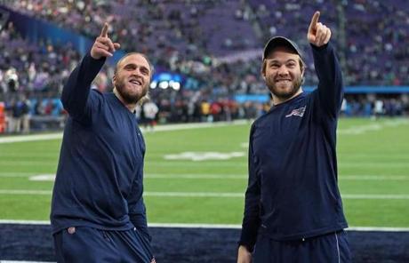 SUPER BOWL SLIDER1 Minneapolis, MN 2/4/2018: Steve Belichick (left) and his brother Brian Belichick (right), the sons of Patriots head coach Bill Belichick, smile and point to some friends in the stands who were calling out to them around two hours before kickoff. The New England Patriots play the Philadelphia Eagles in Super Bowl LII at US Bank Stadium in Minneapolis. (Jim Davis/Globe Staff)
