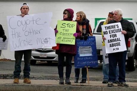 Hyannis, MA- February 010, 2018: Hyannis, MA- February 010, 2018: A counter demonstrator joins protestors with a conflicting sign during a protest outside Powderhorn Outfitters in Hyannis, MA on February 10, 2018. Boston Animal Save organized the event to protest the outfitter's coyote hunting contest. (Craig F. Walker/Globe Staff) section: metro reporter: 

