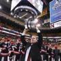 Northeastern University head coach Jim Madigan held up the Beanpot trophy after they defeated Boston University.