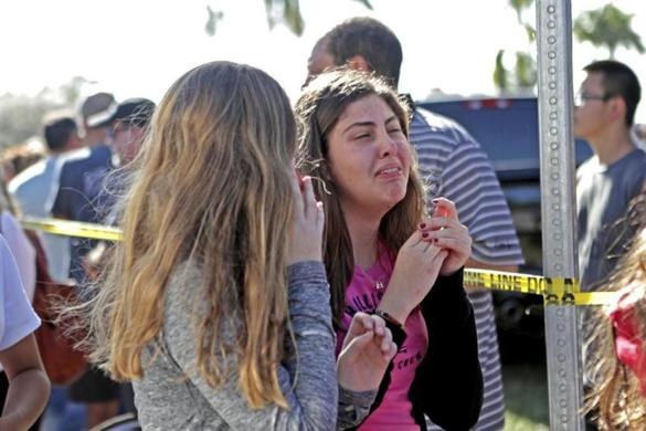 Students released from a lockdown are overcome with emotion following following a shooting at Marjory Stoneman Douglas High School in Parkland, Fla., Wednesday, Feb. 14, 2018. (John McCall/South Florida Sun-Sentinel via AP)