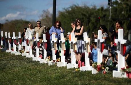 People visited a memorial Sunday for victims of the shooting rampage at the Marjory Stoneman Douglas High School in Parkland, Fla., where 17 people were killed last week.

