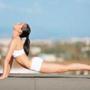 Shot of an attractive young woman in workout gear doing yoga on a rooftop