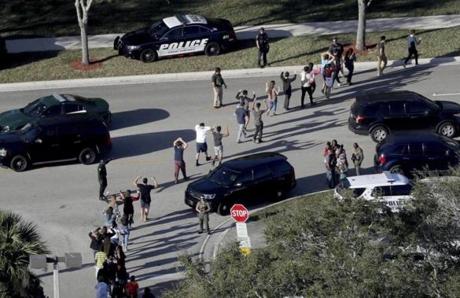 Students held their hands in the air as they were evacuated by police from Marjory Stoneman Douglas High School in Parkland, Fla.,after last week?s shooting that left 17 dead.  
