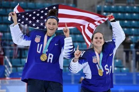 USA's Megan Keller (L) holds the US flag with teammate Danielle Cameranesi after the medal ceremony after winning the women's ice hockey event during the Pyeongchang 2018 Winter Olympic Games at the Gangneung Hockey Centre in Gangneung on February 22, 2018. / AFP PHOTO / JUNG Yeon-JeJUNG YEON-JE/AFP/Getty Images

