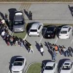 FILE - In this Feb. 14, 2018, file photo, students are evacuated by police from Marjory Stoneman Douglas High School in Parkland, Fla., after a shooter opened fire on the campus. Modern technology has enabled real-time reaction, support and calls for action during deadly mass shootings in the U.S. Live video of the Florida shooting showed survivors under desks while others live-tweeted messages to the survivors. (Mike Stocker/South Florida Sun-Sentinel via AP, File)