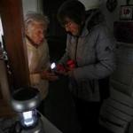 Residents Leona Silva (left) and Shirley Conniff checked the batteries in some flashlights while waiting for power to be restored on Thursday.