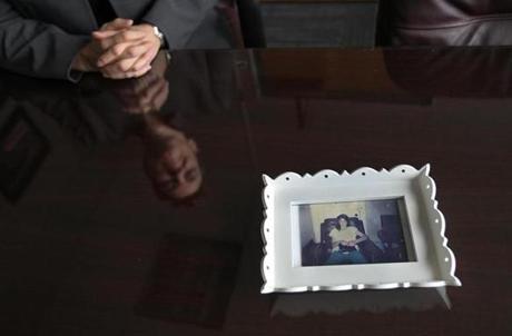 Framingham, MA., 03/28/17, State Police Major Kerry Gilpin, reflected in table, became a trooper in part because her sister, Tracy Gilpin, in photo, was murdered in October 1986. The teenager left a party to buy cigarettes and disappeared. Now, 31 years later, the case remains unsolved. But the Gilpin family is hoping to draw attention to it again, in hopes that someone will come forward with information. Globe staff/Suzanne Kreiter
