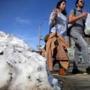 Pedestrians made their way past a pile of melting snow during a warm day last month.  