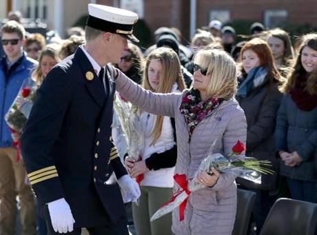Watertown Deputy Fire Chief Tom McManus gave flowers to Maureen Toscano at the dedication of a plaque to her late husband, firefighter Joseph A. Toscano, at the corner of Merrifield and Bigelow avenues. 
