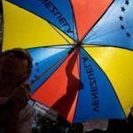 A person opens an umbrella with the colors of the Venezuelan flag during a demonstration against the presidential elections in Caracas Saturday. 