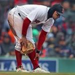 Boston, MA: 4/8/2018: Red Sox SS Xander Bogaerts reaches for his left ankle after he was injured chasing an errant seventh inning throw. He had to leave the game. The Boston Red Sox hosted the Tampa Bay Rays in a regular season baseball game at Fenway Park. (Jim Davis/Globe Staff)