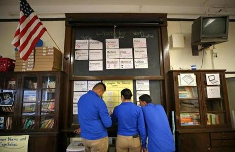 BOSTON, MA - 11/02/2017: Students L-R Csteban Dominguez, Kelly Tobar and Ocsar Lemus working on their english lesson on the board. At East Boston High School, English Language Learners receiving extra support in school. Across East Boston, schools are debunking a long-held misconception that serving large populations of English language learners is an impediment to academic success. Instead more than half of the schools have achieved the highest level in the state's school accountability system, with a few receiving commendations from the state. (David L Ryan/Globe Staff ) SECTION: METRO TOPIC 05bostonschools
