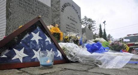 Rain wets the floral tribute to fallen officer Sean Gannon outside the Yarmouth Police Station on Friday, April 13, 2018. Thomas Latanowich is charged with killing a Massachusetts police officer serving an arrest warrant was held without bail during a brief arraignment Friday, April 13, 2018. Latanowich, 29, hung his head throughout the appearance in Barnstable District Court, speaking only to answer 