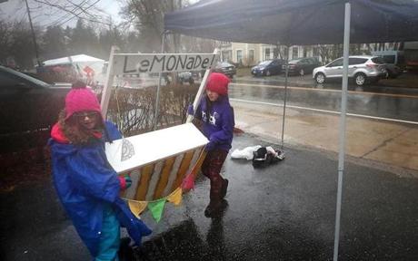 MARATHON SLIDER HOPKINTON, MA - 4/16/2018: L-R Payton Richard (cq) and Lila Harber (cq) calling it a day and a rough one at that for these two business women selling lemonade then changing to hot chocolate all done for charity near the Boston Marathon Start...bad waether cut down 