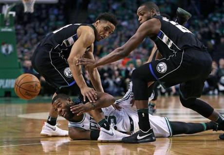 Boston, MA: 4/15/18: The Celtics Greg Monroe gets off a first half pass despite being on the floor and surrounded by the Bucks Malcolm Brogdon and Khris Middleton. The Boston Celtics hosted the Milwaukee Bucks in Game One of an Eastern Conference First Round NBA Playoff basketball game at the TD Garden. (Jim Davis/Globe Staff)
