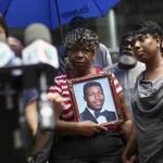 FILE -- Gwen Carr holds a portrait of her son Eric Garner in New York, July 6, 2015. Forty-three months after a New York police officer wrapped his arms around Garner?s neck in a chokehold that helped cause his death in July 2014, his family is still waiting for closure. ?We?ve been waiting for almost four years. Waiting time is over,? Carr said. (Mark Kauzlarich/The New York Times)