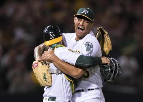 Oakland Athletics starting pitcher Sean Manaea, right, celebrates with catcher Jonathan Lucroy after pitching a no-hitter against the Boston Red Sox during a baseball game in Oakland, Calif., Saturday, April 21, 2018. The A's won 3-0. (AP Photo/John Hefti)
