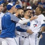 Toronto Blue Jays' Curtis Granderson welcomed by teammates after he hit a walk-off home run against the Boston Red Sox during the 10th inning of a baseball game Tuesday, April 24, 2018, in Toronto. Toronto won 4-3. (Fred Thornhill/The Canadian Press via AP)