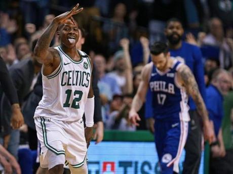 Boston, MA: 5-3-18: After hitting a three pointer that put Boston ahead 99-95, the Celtics Terry Rozier III (12) reacts, while the 76ers J.J. Redick (17) is not as happy in the backround. The Boston Celtics hosted the Philadelphia 76ers in Game Two of their NBA Eastern Conference Semi Final playoff series at the TD Garden. (Jim Davis/Globe Staff)
