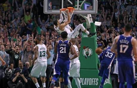 Boston, MA: 5-3-18: The Celtics Jayson Tatum hangs around the rim after his slam dunk on a nice feed from teamamte Terry Rozier III brought the crowd out of their seats and gave Boston a 103-97 lead, on their way to a 108-103 victory. The Boston Celtics hosted the Philadelphia 76ers in Game Two of their NBA Eastern Conference Semi Final playoff series at the TD Garden. (Jim Davis/Globe Staff)
