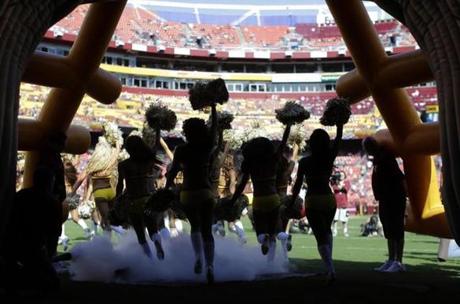 FILE - In this Aug. 24, 2013, file photo, Washington Redskins cheerleaders run out of a tunnel before an NFL preseason football game against the Buffalo Bills in Landover, Md. The Redskins say they're concerned by allegations made by cheerleaders in a New York Times article about a trip to Costa Rica for a photo shoot in 2013. Team president Bruce Allen said in a statement Thursday, May 3, 2018, that the organization is immediately looking into the situation. (AP Photo/Patrick Semansky, File)
