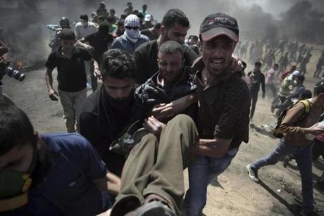 Palestinian protesters carried an injured man, who they say was shot by Israeli troops, away from the scene of a protest along the Gaza Strip-Israel border on Monday. 
