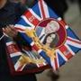 A visitor carries a bag featuring Britain's Prince Harry and US actress Meghan Markle in Windsor on May 17, 2018, two days before the Royal wedding. Britain's Prince Harry and US actress Meghan Markle will marry on May 19 at St George's Chapel in Windsor Castle. / AFP PHOTO / Oli SCARFFOLI SCARFF/AFP/Getty Images