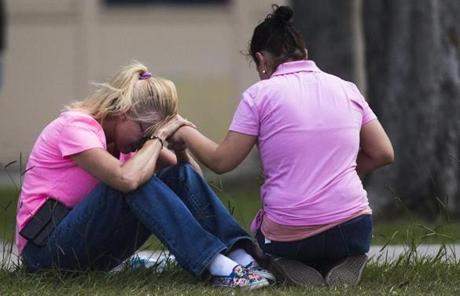 TEXAS SHOOTING SLIDER Two women pray outside the family reunification site following a shooting at Santa Fe High School on Friday, May 18, 2018, in Santa Fe, Texas. (Marie D. De Jesus /Houston Chronicle via AP)
