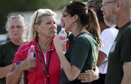 TEXAS SHOOTING SLIDER Santa Fe High School staff react as they gather in the parking lot of a gas station following a shooting at the school in Santa Fe, Texas, on Friday, May 18, 2018. (Jennifer Reynolds/The Galveston County Daily News via AP)
