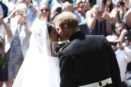Prince Harry and Meghan Markle kiss on the steps of St. George?s Chapel after the wedding ceremony.
