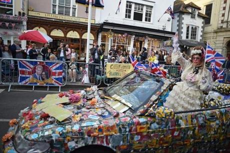 A woman waves from an elaborately decorated car to Royal well-wishers.
