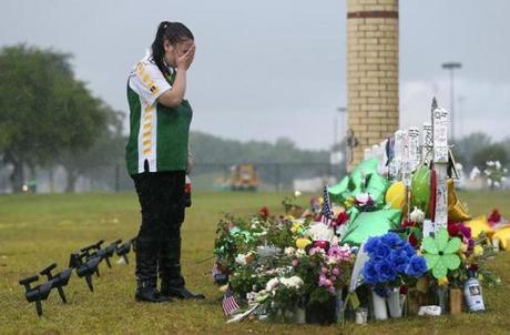 A teen visits a memorial to the shooting victims at Santa Fe High School in Texas.
